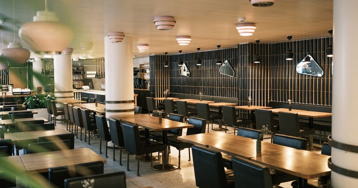 Empty modern restaurant interior with tables and chairs.